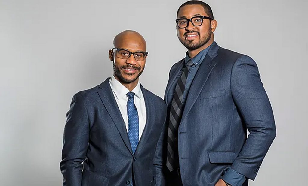 two men in suits smiling