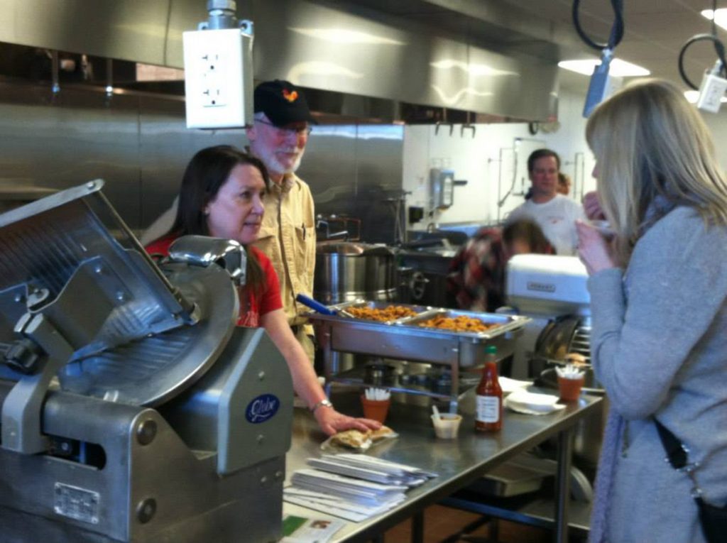 people serving food in a kitchen