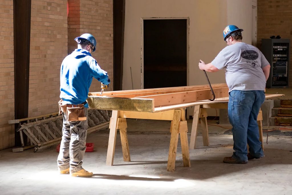 two people working construction inside