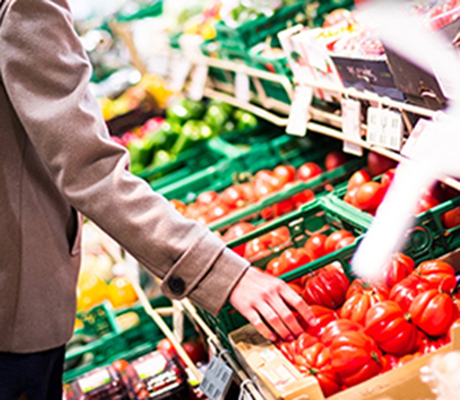Person picking out a vegetable at the grocery store