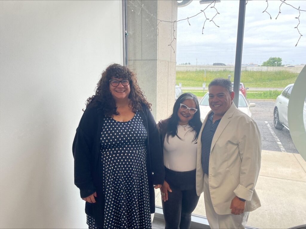 Photo of three people smiling at closing